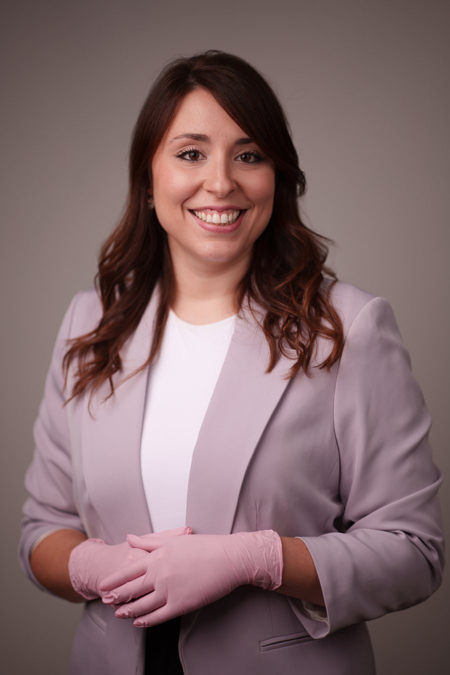 Sofía Perticone sonriendo, con americana lila y guantes rosas de trabajo